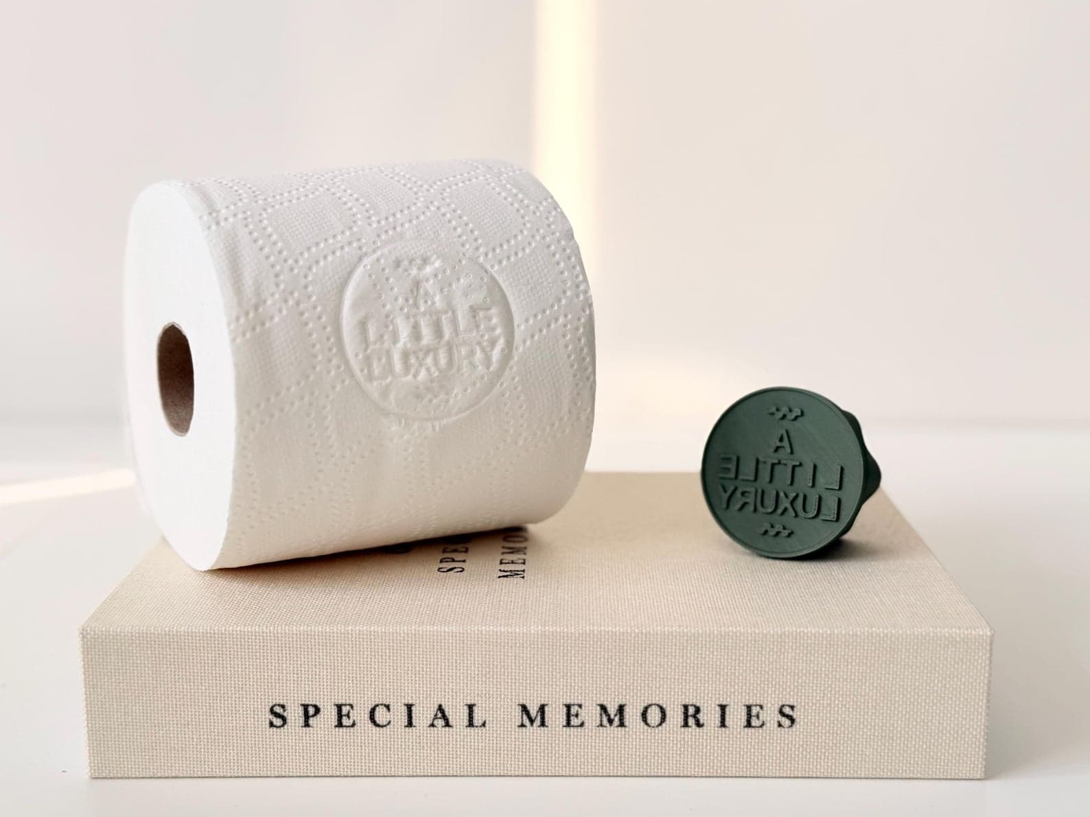 Toilet roll stamper embossing 'Enjoy Your Stay' onto toilet paper